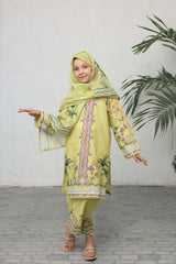 Child wearing a yellow embroidered outfit with a matching hijab in a minimal indoor setting.