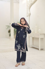 Person wearing a navy blue embroidered outfit in a white room