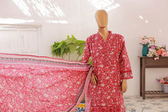 Mannequin wearing a red floral dress with pink fabric in a room setting.