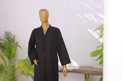 Black dress on a mannequin against a white background with plants.