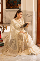 Woman in a traditional outfit sitting on a couch in a decorated room.