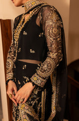 Black embroidered outfit with gold details on a plain background