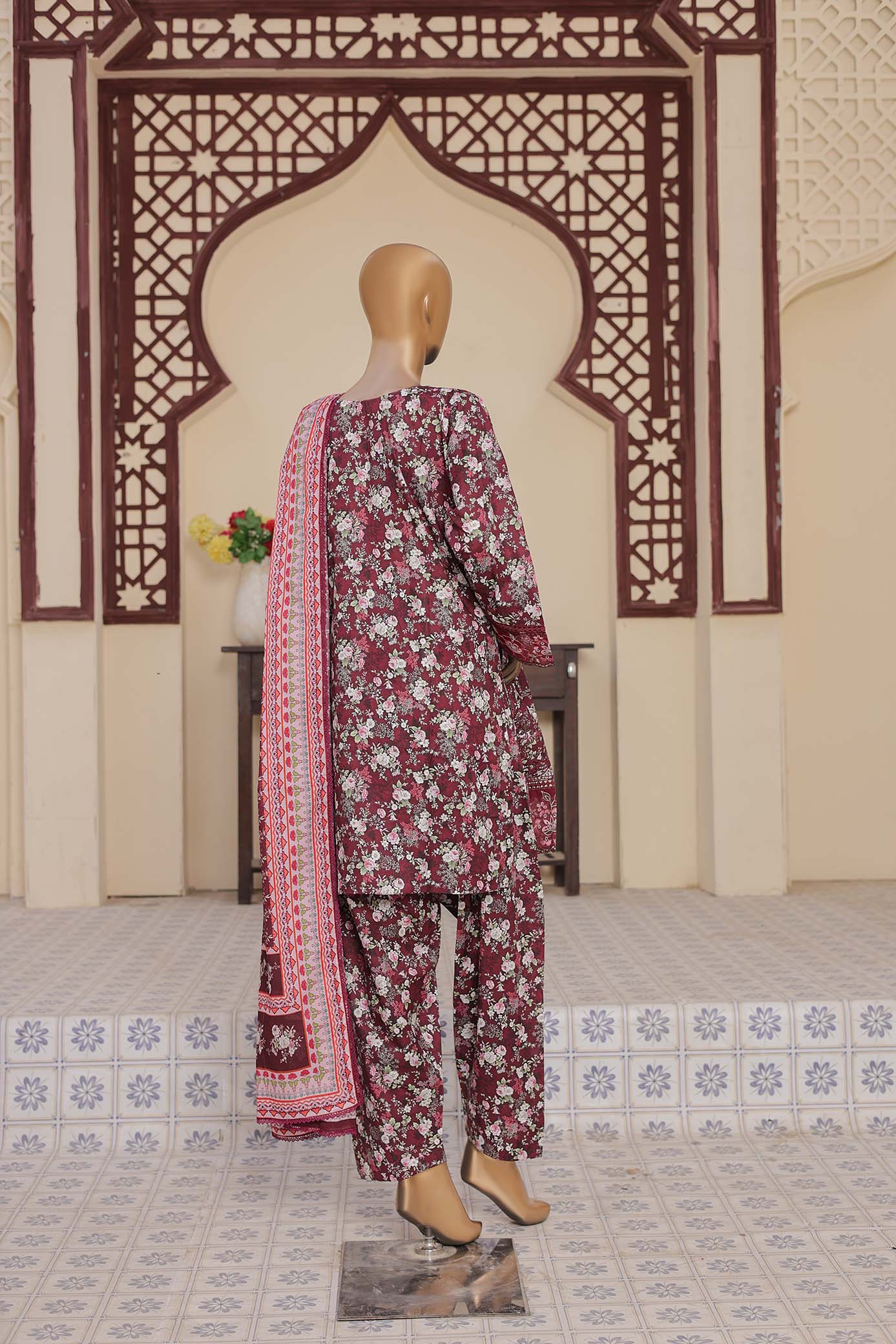 Mannequin wearing a traditional outfit with a floral pattern in a decorated room.