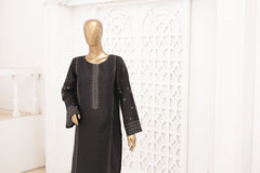 Black dress on a mannequin against a white wall with decorative patterns