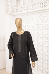 Black dress with intricate embroidery on a mannequin against a decorative white wall.