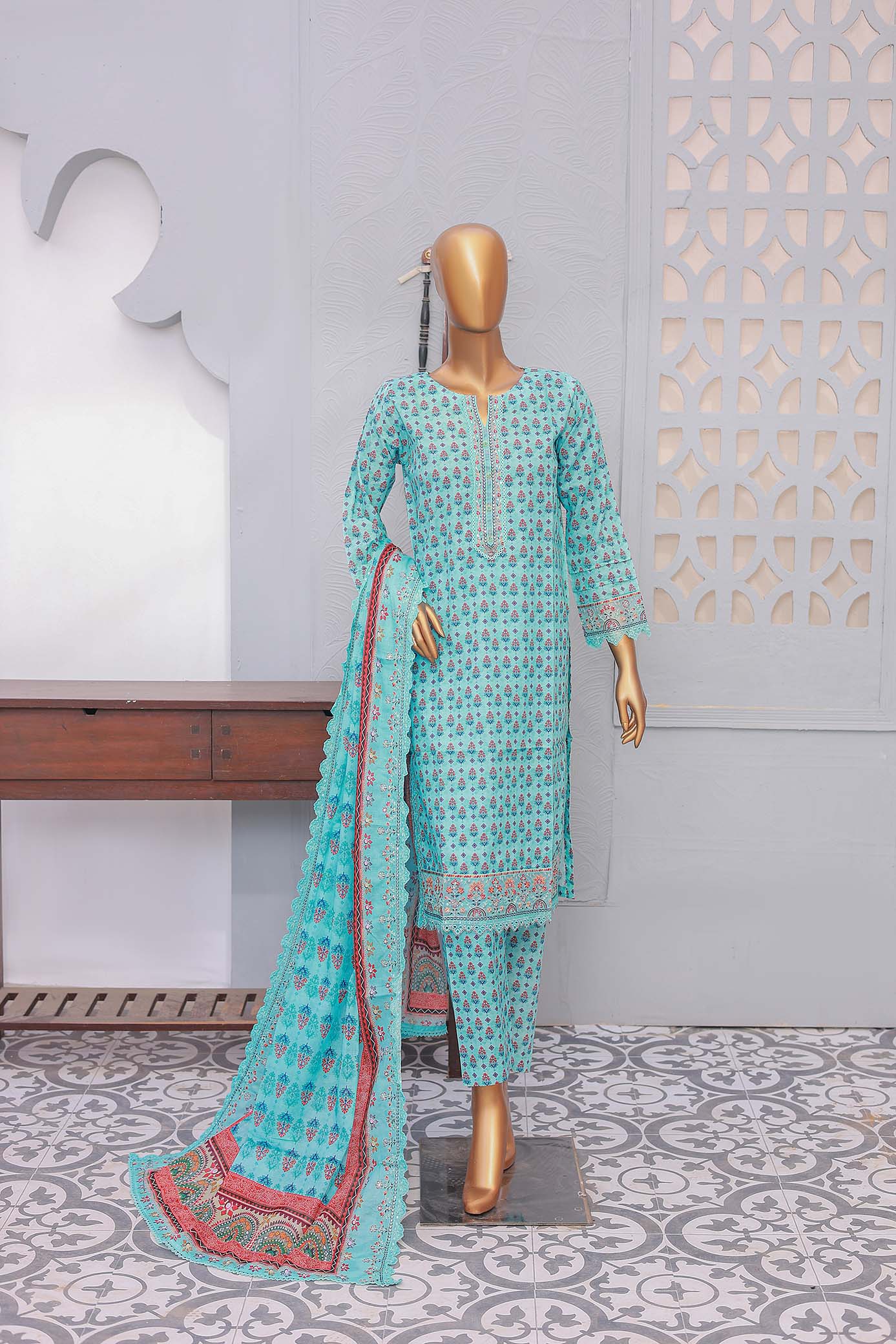 A three-piece blue festive embroidered outfit consisting of a shirt with front and sleeve embroidery, trousers, and a dupatta with cutwork, displayed on a mannequin against an ornate background.