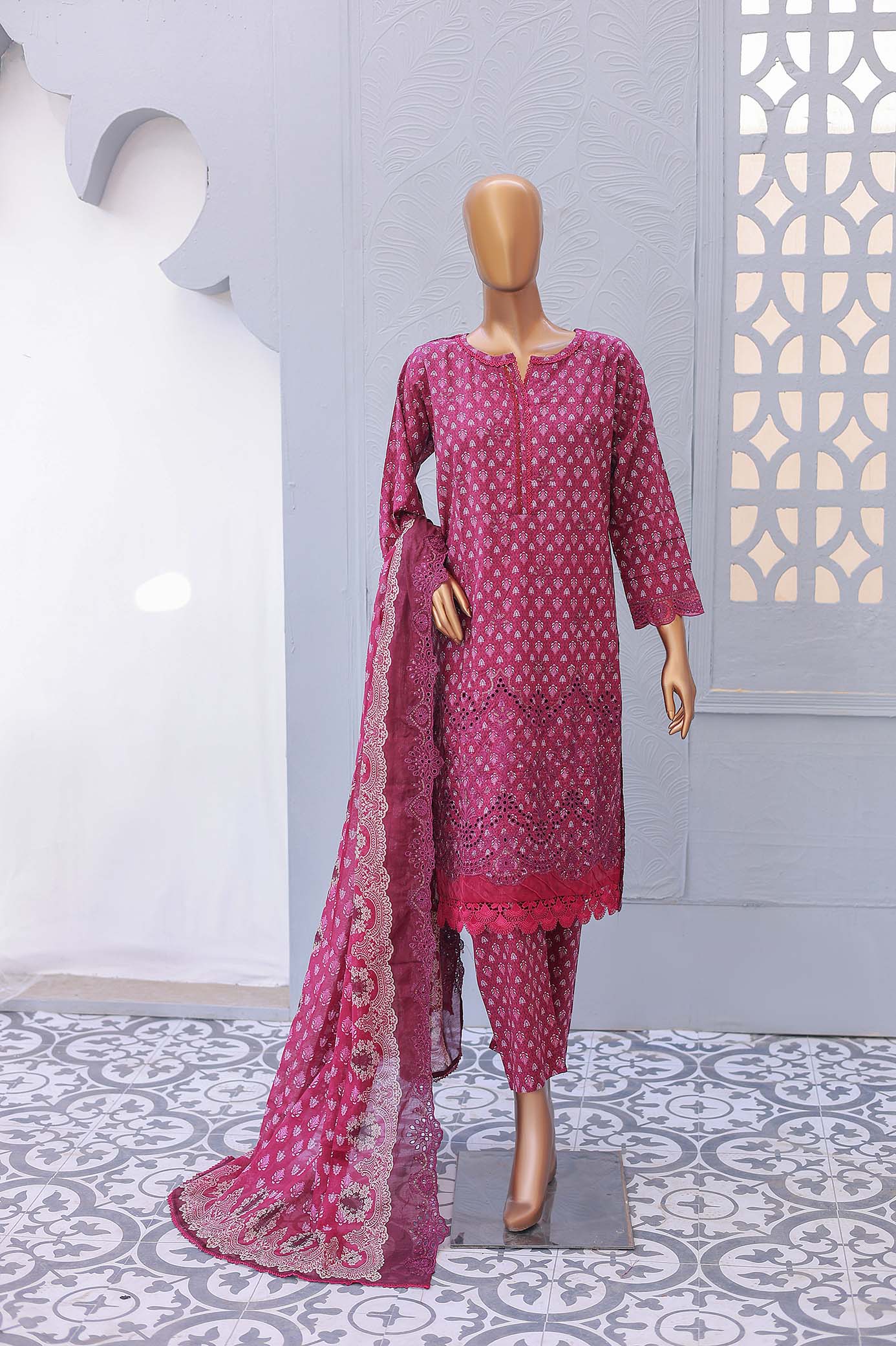 A three-piece festive embroidered outfit comprising a shirt with front and sleeve embroidery, laser cutwork embellishments, trousers, and a dupatta with printed cutwork.